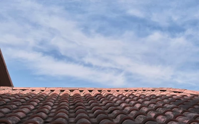 Pose de toiture à neuf à Toulon : une couverture durable et performante - toit-en-tuiles-contre-un-ciel-bleu-avec-des-nuages-une-idee-pour-un-fond-avec-un-espace-reserve-au-texte-toits-traditionnels-respectueux-de-l-environnement-pour-la-maison Pose de toiture à neuf à Toulon : une couverture durable et performante